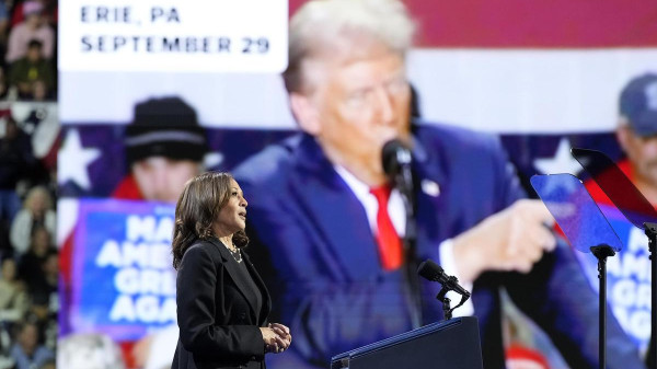 Un comizio di Kamala Harris In Pennsylvania con l'immagine di Donald Trump sul megaschermo