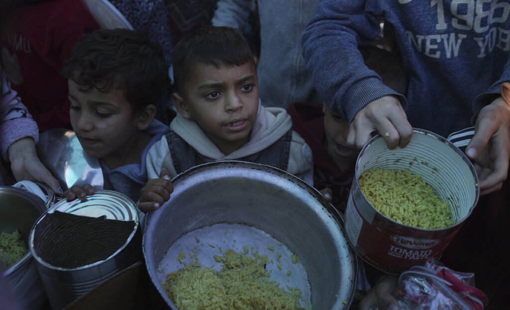 Bambini palestinesi in fila per il cibo a Deir al-Balah, nella Striscia di Gaza (dicembre 2024) - AP Photo/Abdel Kareem Hana/LaPresse